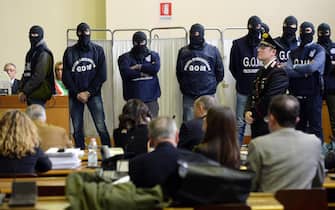 Agenti della polizia penitenziaria incapucciati nell'aula bunker per la deposizione del pentito Giovanni Brusca all'udienza sulla trattativa Stato-mafia, Milano, 11 dicembre 2013. ANSA/DANIEL DAL ZENNARO