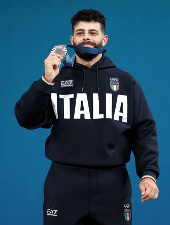 PARIS, FRANCE - AUGUST 09: Bronze medallist Antonino Pizzolato of Team Italy poses on the podium during the Weightlifting Men's 89kg medal ceremony after the Weightlifting Men's 89kg on day fourteen of the Olympic Games Paris 2024 at South Paris Arena on August 09, 2024 in Paris, France. (Photo by Lars Baron/Getty Images)